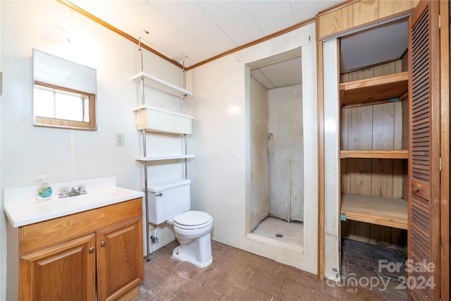 bathroom featuring a shower, crown molding, vanity, and toilet