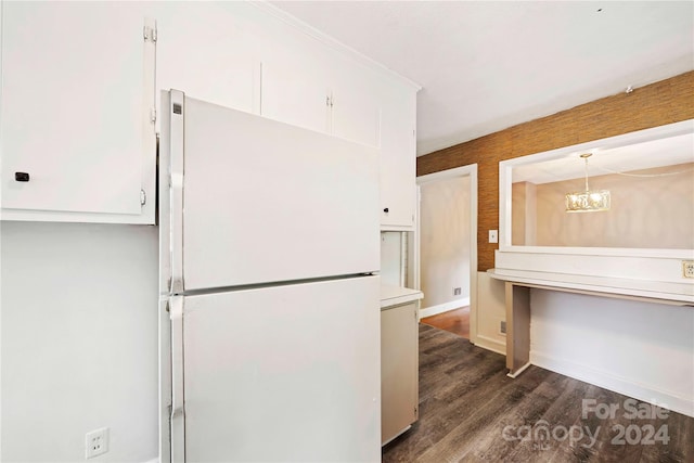 kitchen with dark wood-type flooring, hanging light fixtures, white fridge, a chandelier, and white cabinets