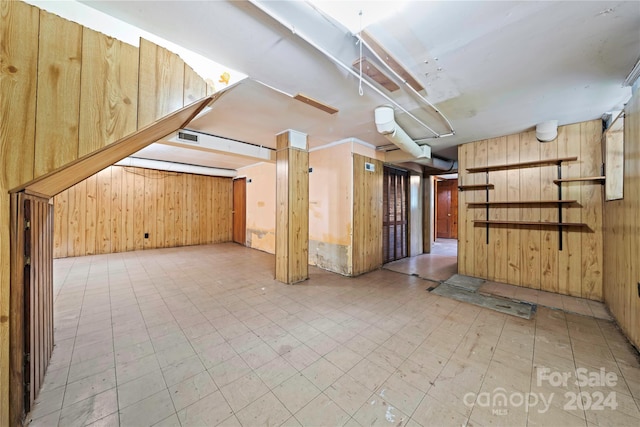 basement featuring wood walls