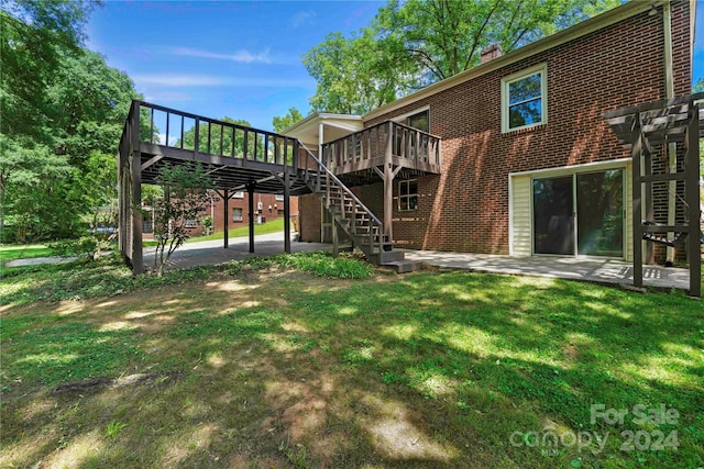 back of house with a patio area, a yard, and a wooden deck