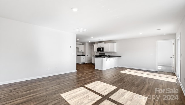 unfurnished living room with dark hardwood / wood-style floors