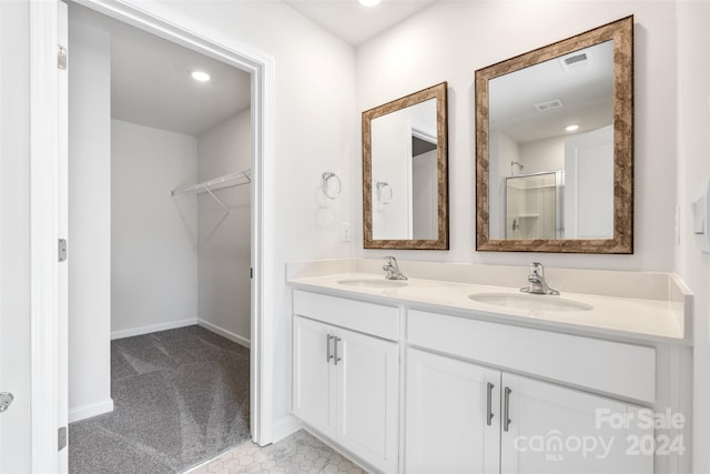 bathroom featuring a shower with door and vanity