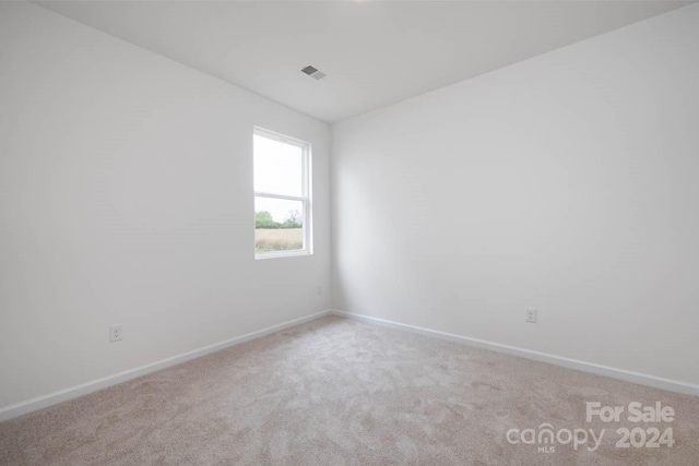 unfurnished room featuring light colored carpet