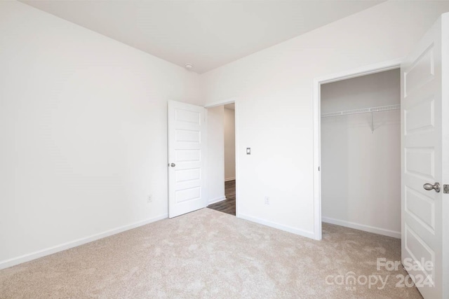 unfurnished bedroom featuring carpet and a closet