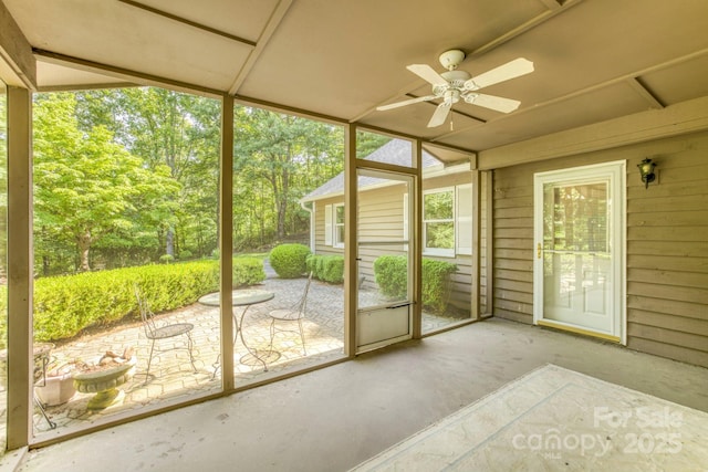 unfurnished sunroom with ceiling fan