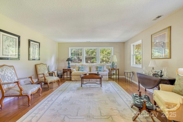 living room with light hardwood / wood-style floors and a textured ceiling