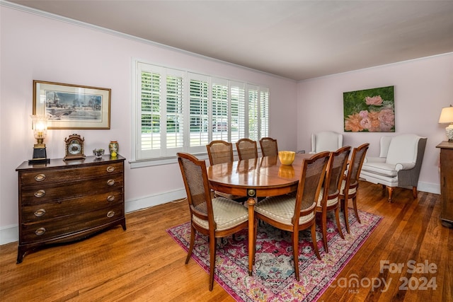 dining space with crown molding and hardwood / wood-style floors