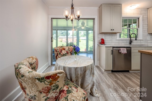 dining area featuring ceiling fan, light wood-type flooring, sink, and ornamental molding