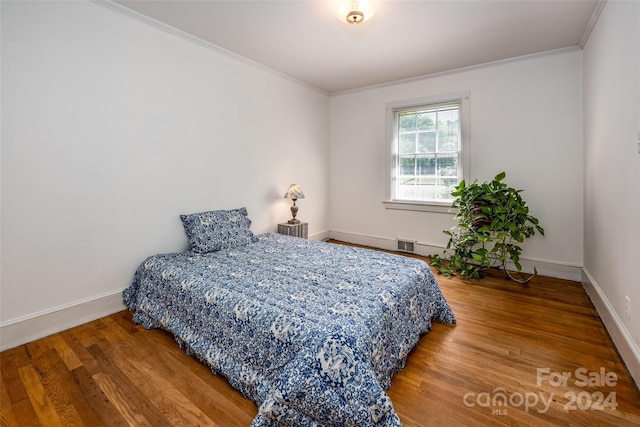 bedroom featuring crown molding and hardwood / wood-style flooring