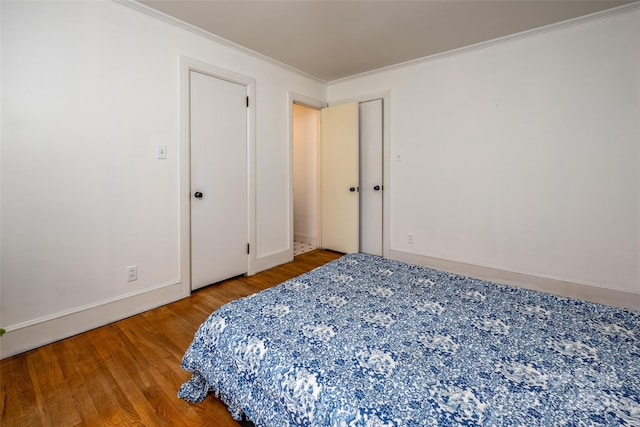 bedroom with crown molding and hardwood / wood-style floors