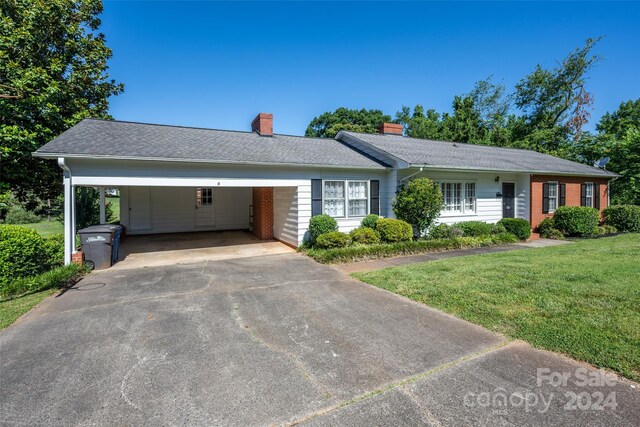 single story home with a front lawn and a carport