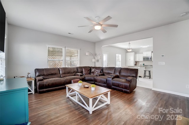 living room with ceiling fan and dark wood-type flooring