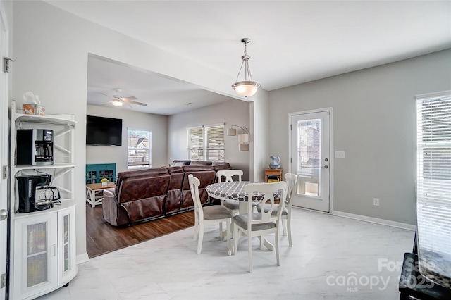 dining room with ceiling fan, a fireplace, and a wealth of natural light