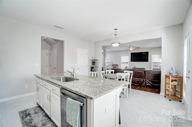 kitchen with pendant lighting, a center island with sink, sink, stainless steel dishwasher, and white cabinetry