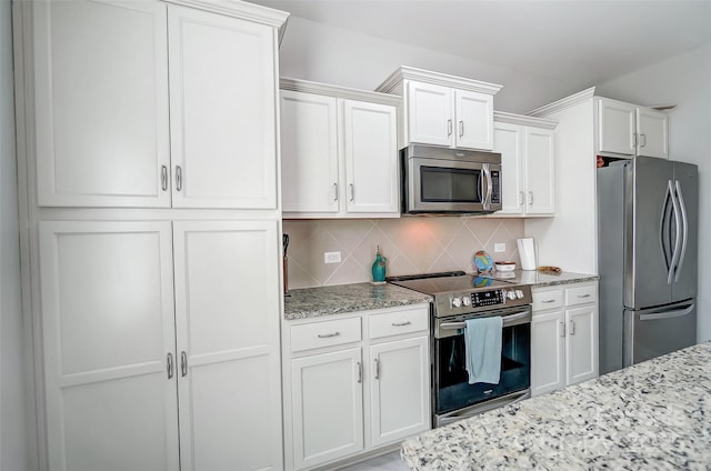 kitchen with tasteful backsplash, white cabinetry, light stone counters, and appliances with stainless steel finishes