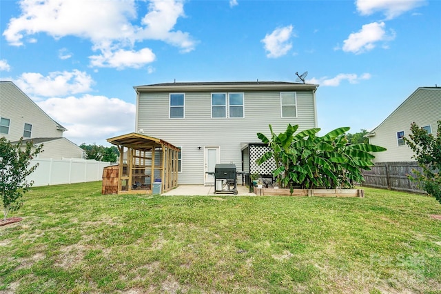 rear view of house with a yard and a patio