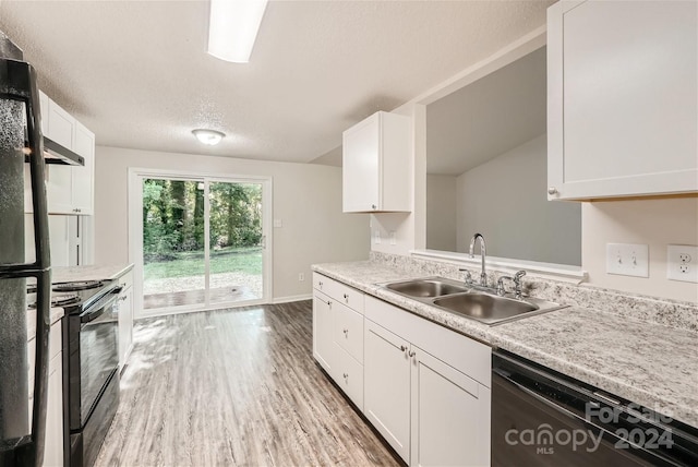 kitchen featuring sink, a textured ceiling, white cabinets, black appliances, and light wood-type flooring