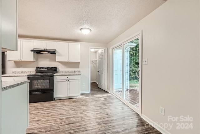 kitchen with white cabinets, a textured ceiling, electric range, and light wood-type flooring