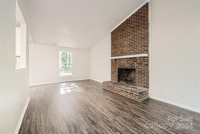 unfurnished living room featuring a fireplace, dark hardwood / wood-style floors, and lofted ceiling