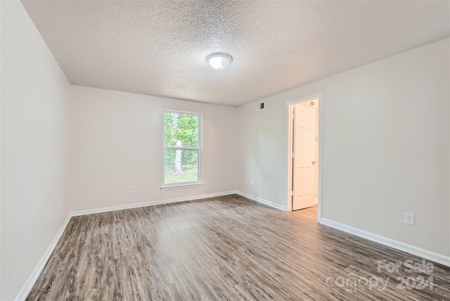 empty room featuring hardwood / wood-style floors and a textured ceiling