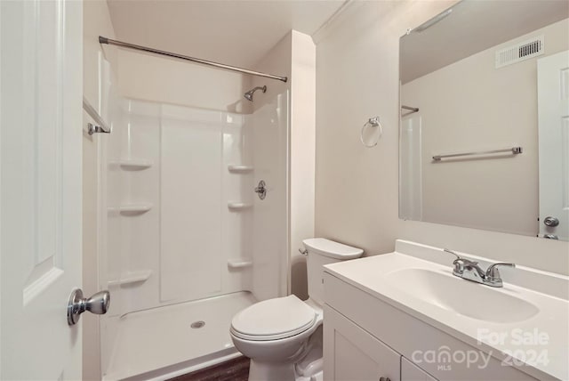 bathroom featuring walk in shower, vanity, and toilet