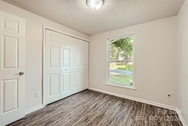 unfurnished bedroom featuring a closet, wood-type flooring, and a textured ceiling