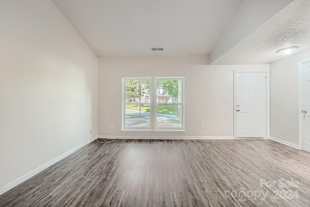 empty room featuring a textured ceiling and hardwood / wood-style flooring