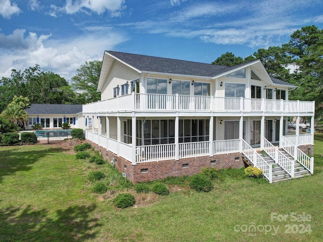 rear view of house featuring a yard and a sunroom