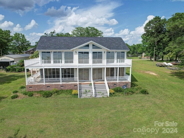 back of house with a sunroom and a lawn