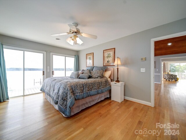 bedroom featuring a water view, access to outside, light hardwood / wood-style floors, and ceiling fan