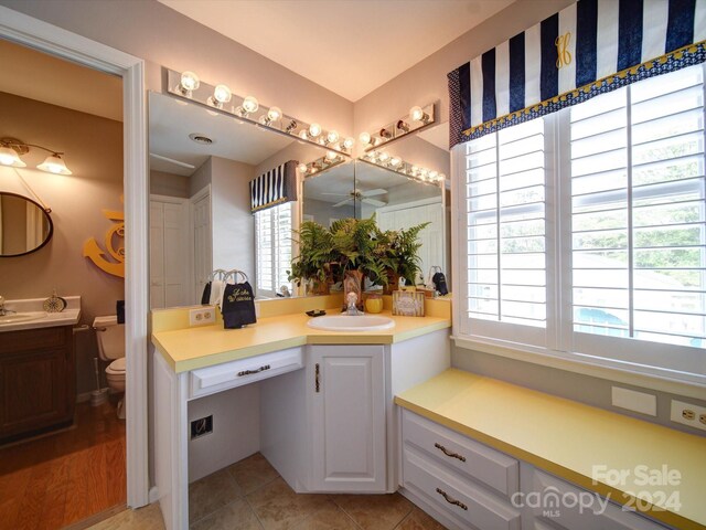 bathroom with toilet, ceiling fan, tile patterned flooring, and vanity