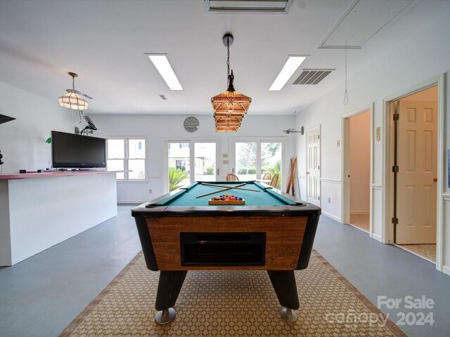 recreation room with billiards, a wealth of natural light, and concrete flooring