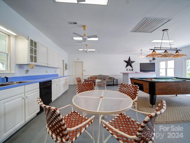 kitchen featuring ceiling fan, pendant lighting, sink, black dishwasher, and white cabinetry