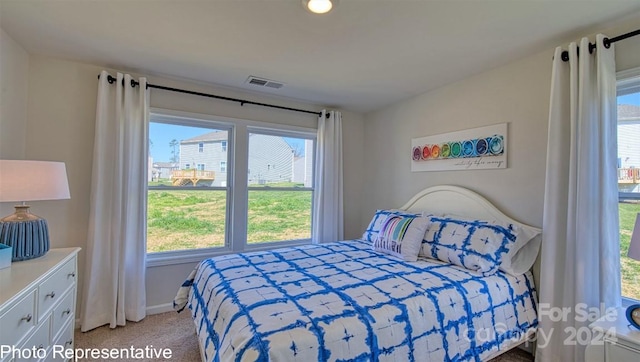 bedroom featuring light carpet and multiple windows