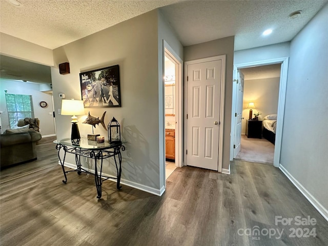 corridor featuring hardwood / wood-style flooring and a textured ceiling