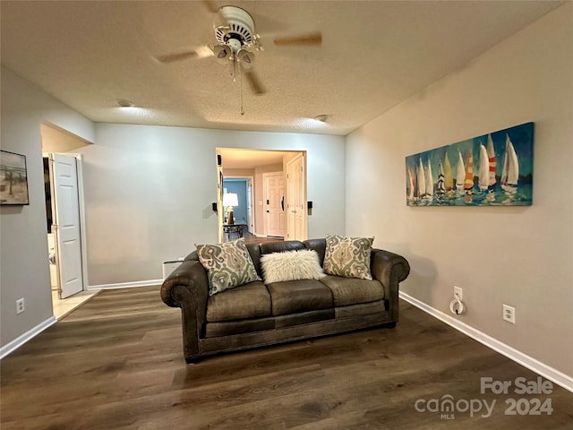 living room with a textured ceiling, dark hardwood / wood-style floors, and ceiling fan