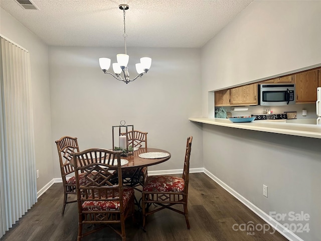 dining area featuring a textured ceiling, a chandelier, and dark hardwood / wood-style floors