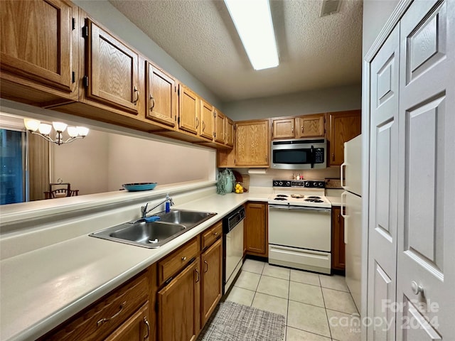 kitchen with appliances with stainless steel finishes, a textured ceiling, sink, light tile patterned floors, and a chandelier