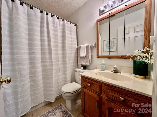 bathroom with tile patterned flooring, vanity, a textured ceiling, and toilet