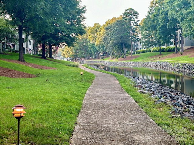 surrounding community featuring a water view and a lawn