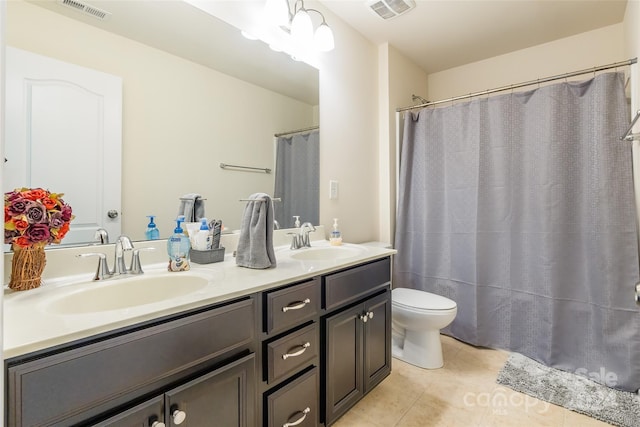 bathroom with tile patterned flooring, vanity, toilet, and walk in shower