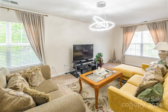 carpeted living room featuring an inviting chandelier