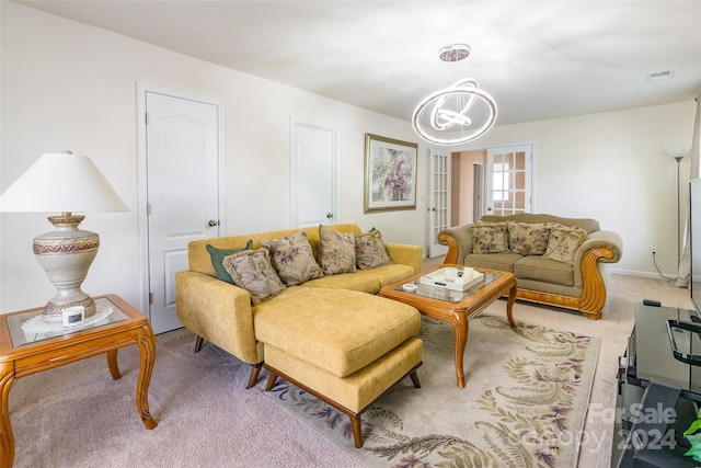 carpeted living room featuring a notable chandelier and french doors