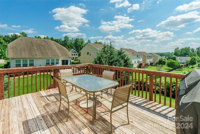 wooden terrace featuring a lawn