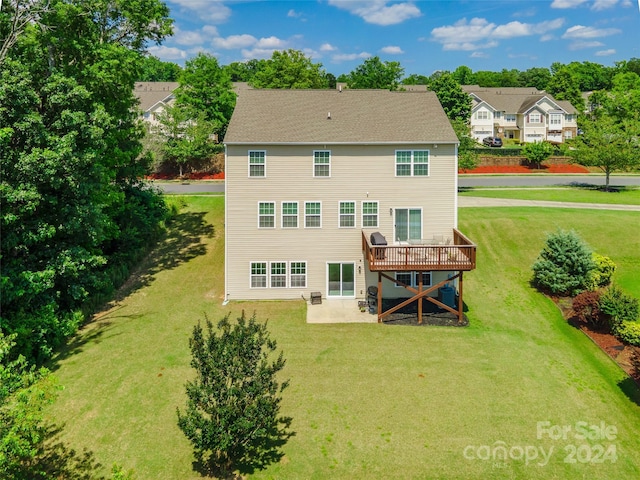 back of property with a yard, a patio area, and a wooden deck