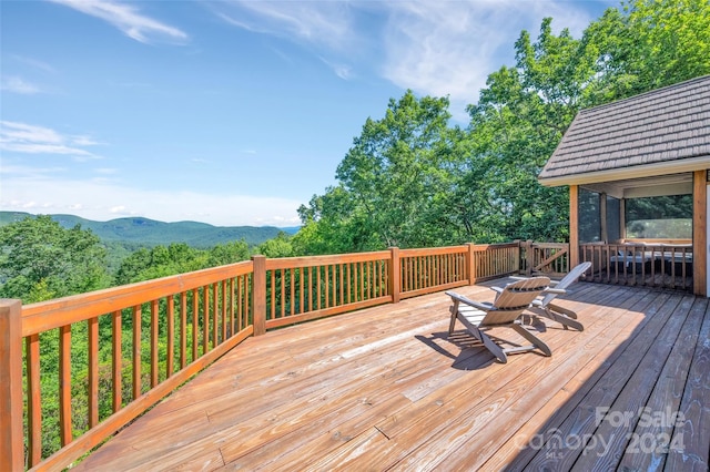 deck featuring a sunroom and a mountain view