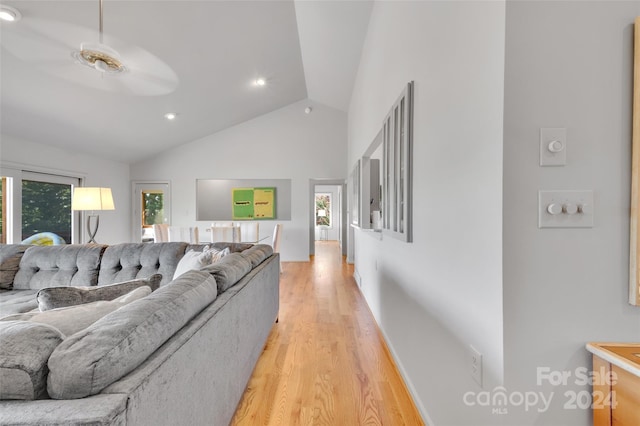 living room featuring ceiling fan, vaulted ceiling, and light hardwood / wood-style flooring