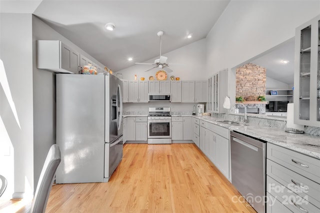 kitchen featuring appliances with stainless steel finishes, light wood-type flooring, gray cabinetry, ceiling fan, and sink