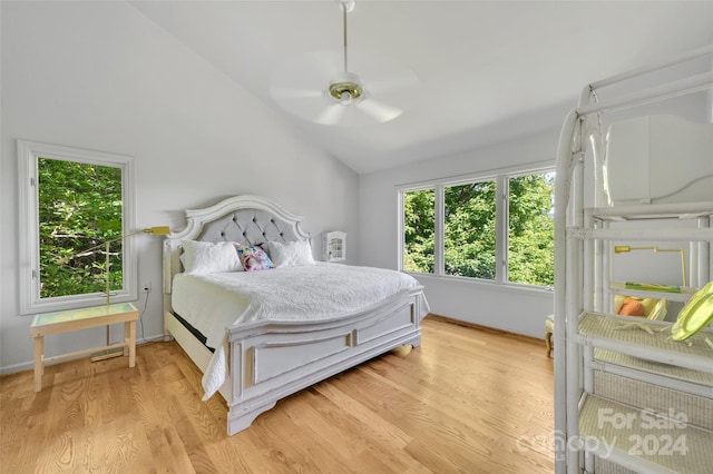 bedroom with ceiling fan, lofted ceiling, and light wood-type flooring