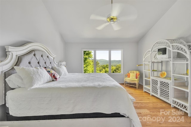 bedroom with hardwood / wood-style flooring, vaulted ceiling, and ceiling fan